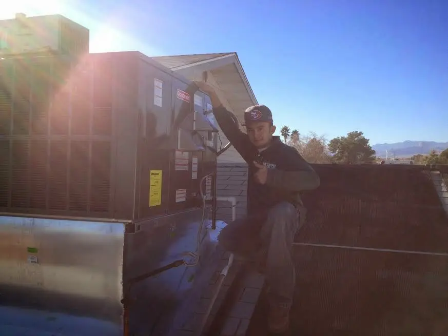 HVAC technician performing Heat Pump Repair on a rooftop unit in St. Augustine